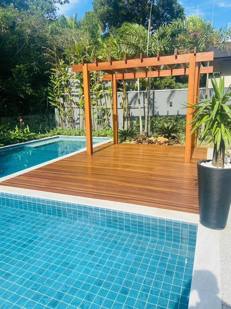 Pérgola e deck de madeira ao lado da piscina